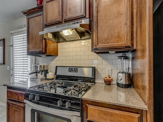 9505 SW 27th St, Oklahoma City, OK 73128 - kitchen with stainless steel gas range oven, under cabinet range hood, backsplash, and light stone countertops