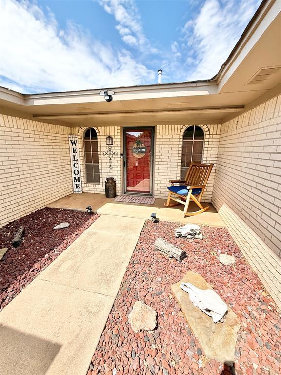 2512 Apache St, Altus, OK 73521 - property entrance with brick siding and covered porch