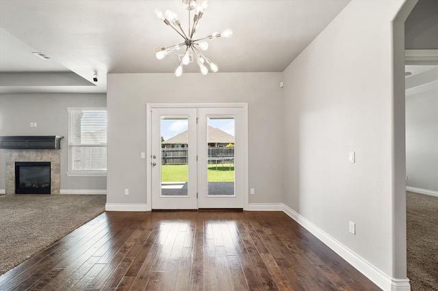 8309 NW 139th Ter, Oklahoma City, OK 73142 - unfurnished living room featuring a chandelier, a glass covered fireplace, and hardwood / wood-style flooring