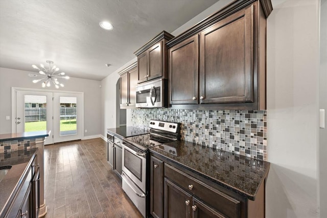 8309 NW 139th Ter, Oklahoma City, OK 73142 - kitchen with stainless steel appliances, a chandelier, dark brown cabinetry, tasteful backsplash, and dark stone counters