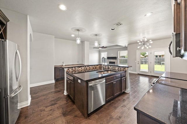 8309 NW 139th Ter, Oklahoma City, OK 73142 - kitchen with appliances with stainless steel finishes, dark brown cabinetry, open floor plan, dark wood-style floors, and recessed lighting
