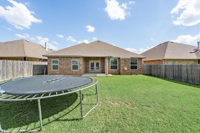 8309 NW 139th Ter, Oklahoma City, OK 73142 - back of property with a trampoline, a fenced backyard, and brick siding
