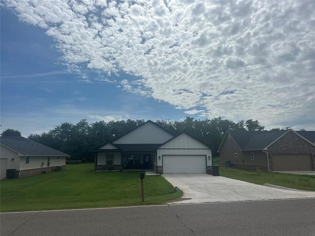 914 S Ash St, Luther, OK 73054 - ranch-style house featuring an attached garage, concrete driveway, a front yard, and board and batten siding