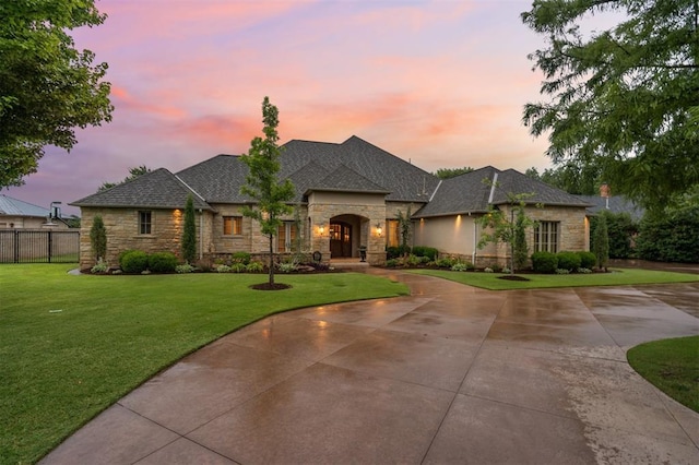 18816 Otter Creek Dr, Edmond, OK 73012 - french country inspired facade featuring stone siding, curved driveway, and roof with shingles