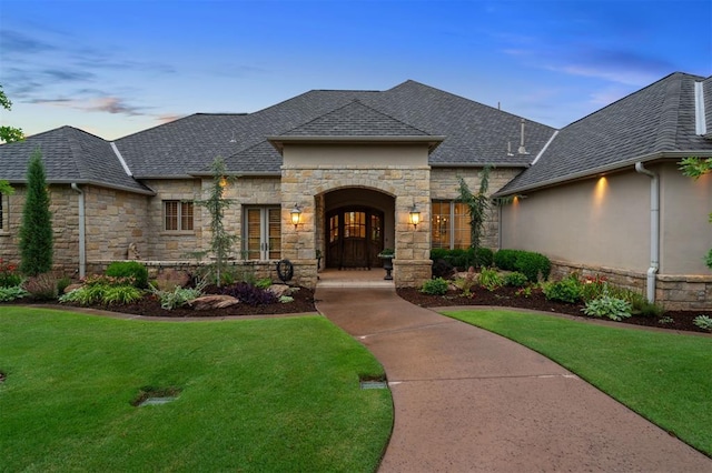 18816 Otter Creek Dr, Edmond, OK 73012 - french country style house with stone siding, a lawn, and roof with shingles