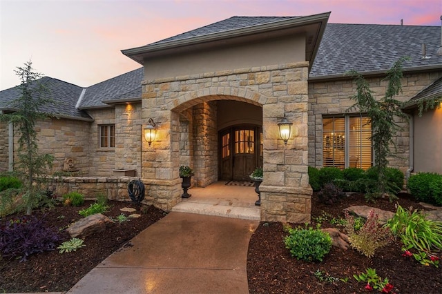 18816 Otter Creek Dr, Edmond, OK 73012 - property entrance with stone siding, roof with shingles, and stucco siding