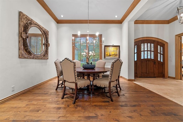 18816 Otter Creek Dr, Edmond, OK 73012 - dining room featuring a chandelier, ornamental molding, wood finished floors, and arched walkways