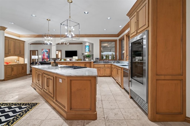 18816 Otter Creek Dr, Edmond, OK 73012 - kitchen with a chandelier, crown molding, arched walkways, appliances with stainless steel finishes, and a center island