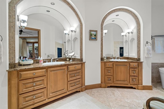 18816 Otter Creek Dr, Edmond, OK 73012 - full bath featuring two vanities, ceiling fan, a soaking tub, and tile patterned flooring