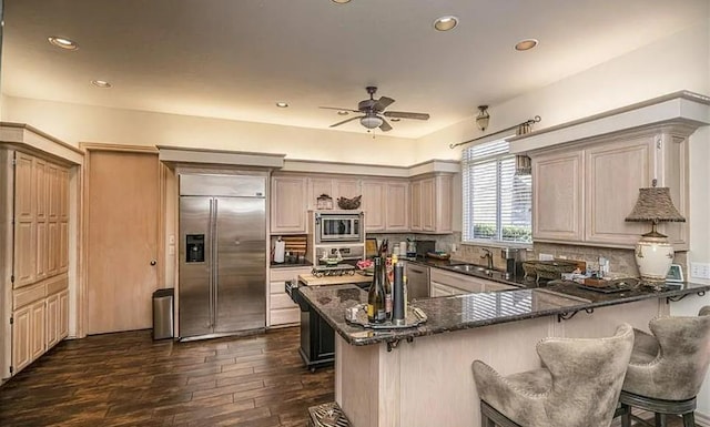 716 Fox Bend Trl, Edmond, OK 73034 - kitchen with built in appliances, ceiling fan, dark wood-type flooring, tasteful backsplash, and a peninsula