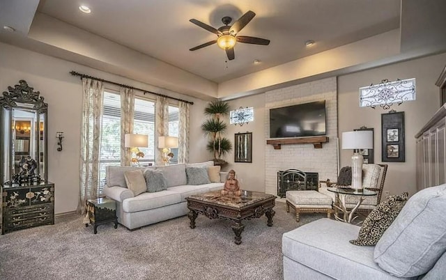 716 Fox Bend Trl, Edmond, OK 73034 - carpeted living room with a raised ceiling, a ceiling fan, a fireplace, and recessed lighting
