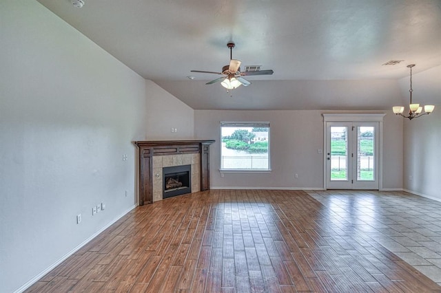 816 Lakeview Dr, Moore, OK 73160 - unfurnished living room with lofted ceiling, a chandelier, healthy amount of natural light, a tile fireplace, and wood finished floors