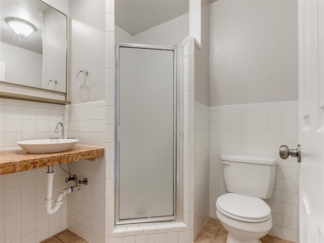 1213 Leslie Ln, Norman, OK 73069 - bathroom with tile walls, a shower stall, tile patterned flooring, and a wainscoted wall