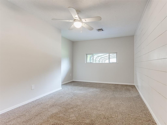 1213 Leslie Ln, Norman, OK 73069 - carpeted spare room with a ceiling fan, wooden walls, and a textured ceiling