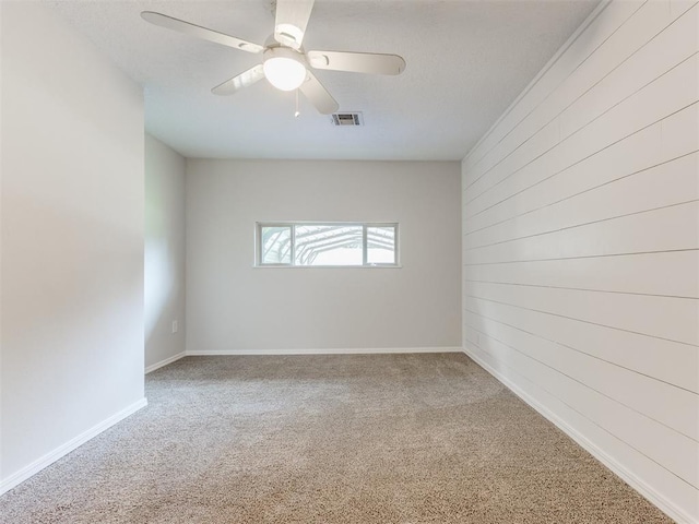 1213 Leslie Ln, Norman, OK 73069 - empty room featuring carpet, wood walls, and ceiling fan