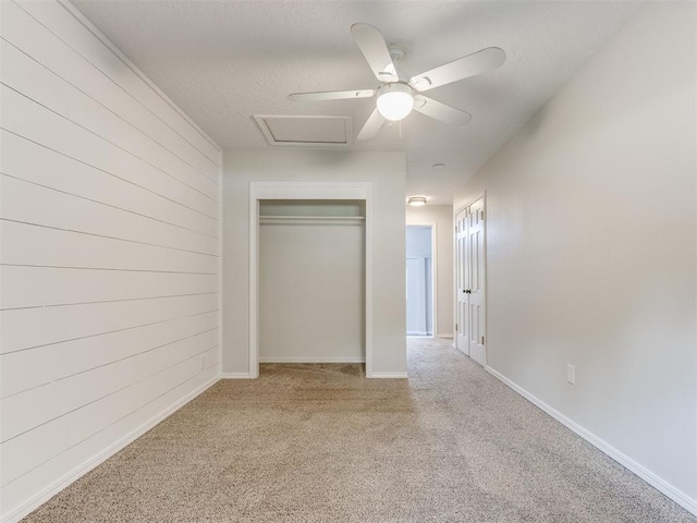 1213 Leslie Ln, Norman, OK 73069 - unfurnished bedroom with carpet floors, a closet, attic access, wooden walls, and a textured ceiling