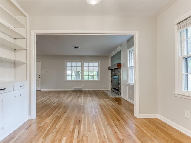 1213 Leslie Ln, Norman, OK 73069 - unfurnished living room with light wood-style flooring and a fireplace