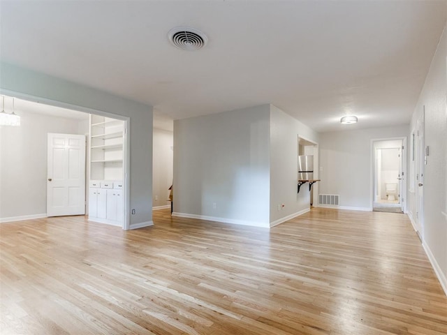 1213 Leslie Ln, Norman, OK 73069 - unfurnished living room with light wood-style floors and baseboards