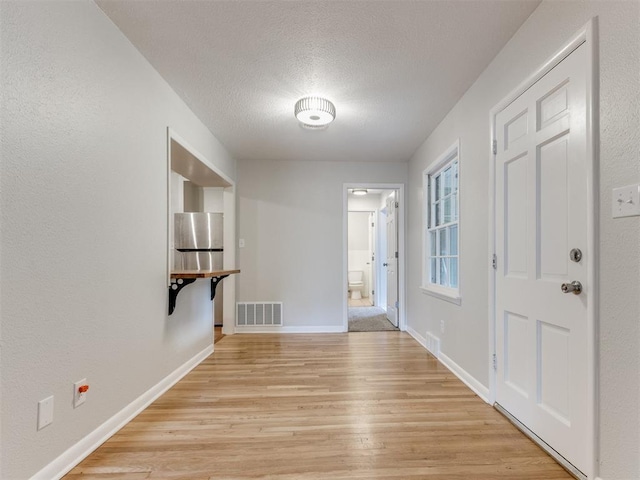 1213 Leslie Ln, Norman, OK 73069 - foyer entrance with light wood-style floors and a textured ceiling