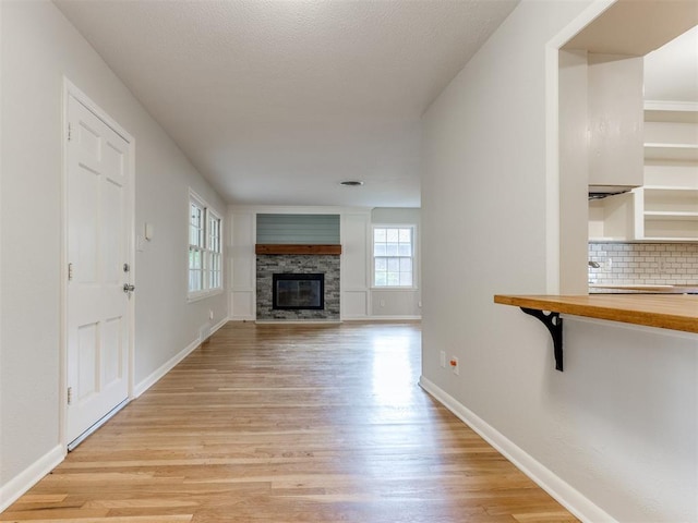 1213 Leslie Ln, Norman, OK 73069 - unfurnished living room featuring light wood finished floors and a fireplace