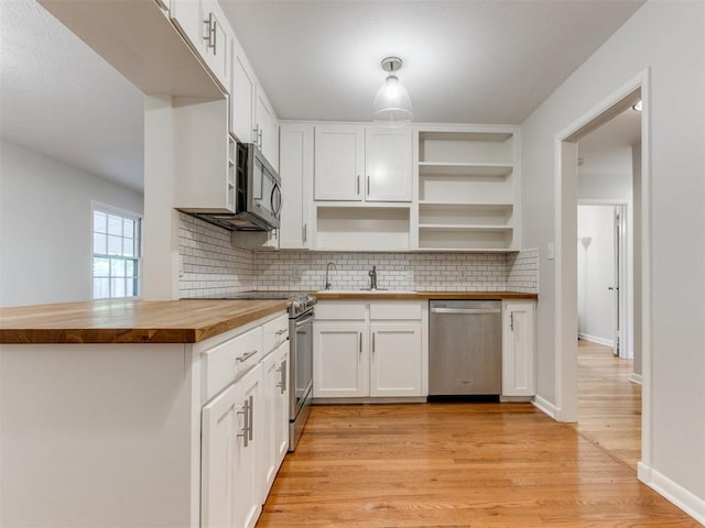 1213 Leslie Ln, Norman, OK 73069 - kitchen with appliances with stainless steel finishes, wooden counters, backsplash, white cabinets, and light wood-style floors