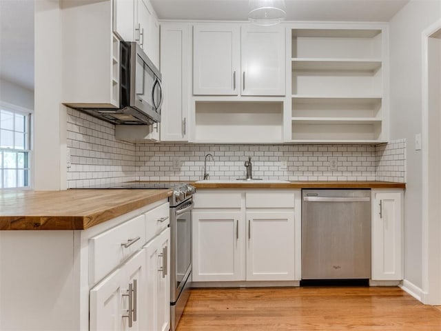 1213 Leslie Ln, Norman, OK 73069 - kitchen with appliances with stainless steel finishes, butcher block countertops, and open shelves