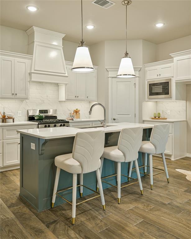 3808 Palmetto Trl, Oklahoma City, OK 73179 - kitchen featuring stainless steel stove, black microwave, custom range hood, backsplash, and light countertops