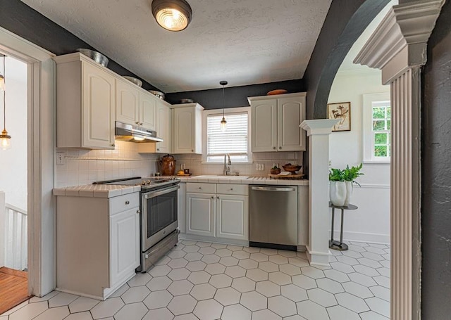 416 W Hill St, Oklahoma City, OK 73118 - kitchen featuring appliances with stainless steel finishes, under cabinet range hood, tile counters, and plenty of natural light