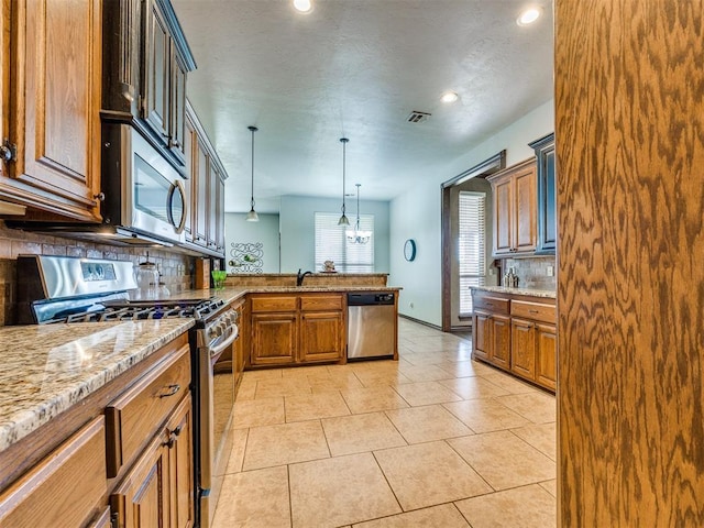 2801 SE 5th St, Moore, OK 73160 - kitchen with appliances with stainless steel finishes, decorative backsplash, a peninsula, light stone counters, and pendant lighting