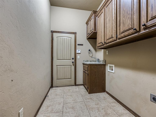 2801 SE 5th St, Moore, OK 73160 - washroom with cabinet space, hookup for an electric dryer, washer hookup, a textured wall, and light tile patterned flooring