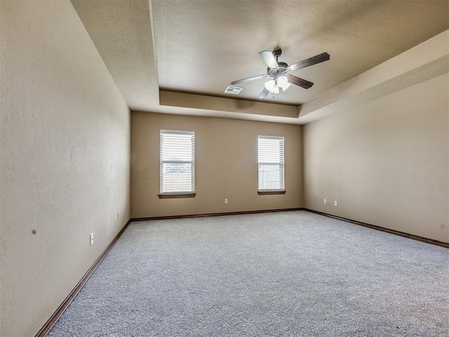 2801 SE 5th St, Moore, OK 73160 - carpeted spare room with ceiling fan, a raised ceiling, a textured ceiling, and a textured wall