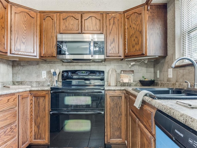 12501 SW 6th St, Yukon, OK 73099 - kitchen with black electric range, stainless steel microwave, dishwashing machine, and backsplash