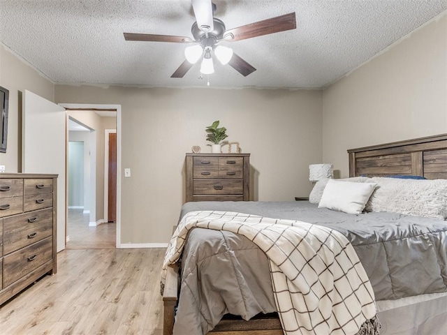 12501 SW 6th St, Yukon, OK 73099 - bedroom with light wood finished floors, a textured ceiling, and a ceiling fan