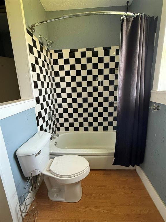223 N Market St, Cordell, OK 73632 - bathroom with shower / bath combo with shower curtain and wood finished floors
