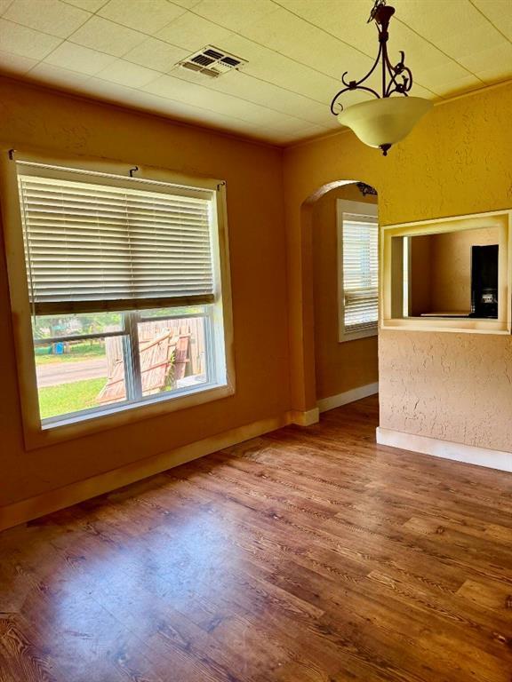 223 N Market St, Cordell, OK 73632 - unfurnished living room with arched walkways and wood finished floors