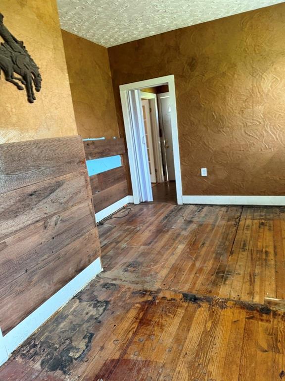 223 N Market St, Cordell, OK 73632 - empty room with hardwood / wood-style floors and baseboards