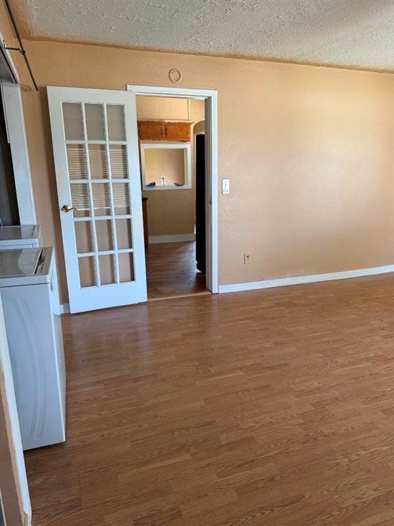 223 N Market St, Cordell, OK 73632 - spare room with wood finished floors, washer / dryer, and a textured ceiling