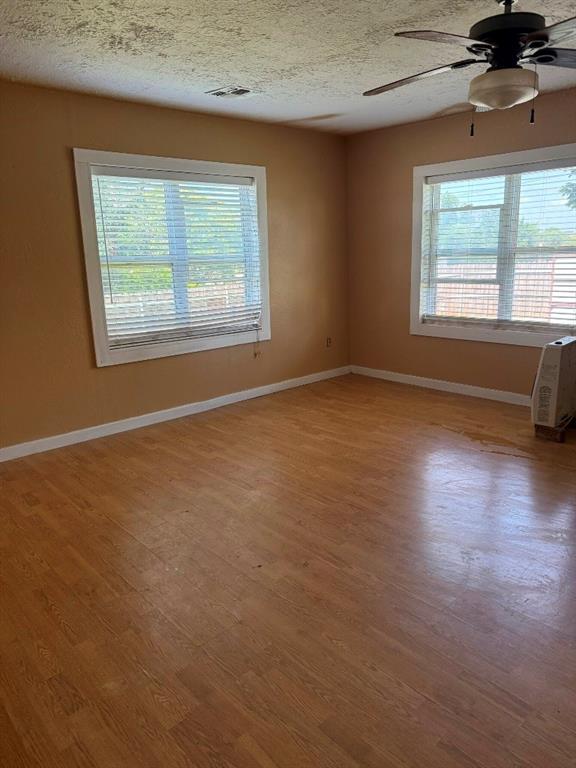 223 N Market St, Cordell, OK 73632 - unfurnished room featuring a ceiling fan, wood finished floors, and a textured ceiling