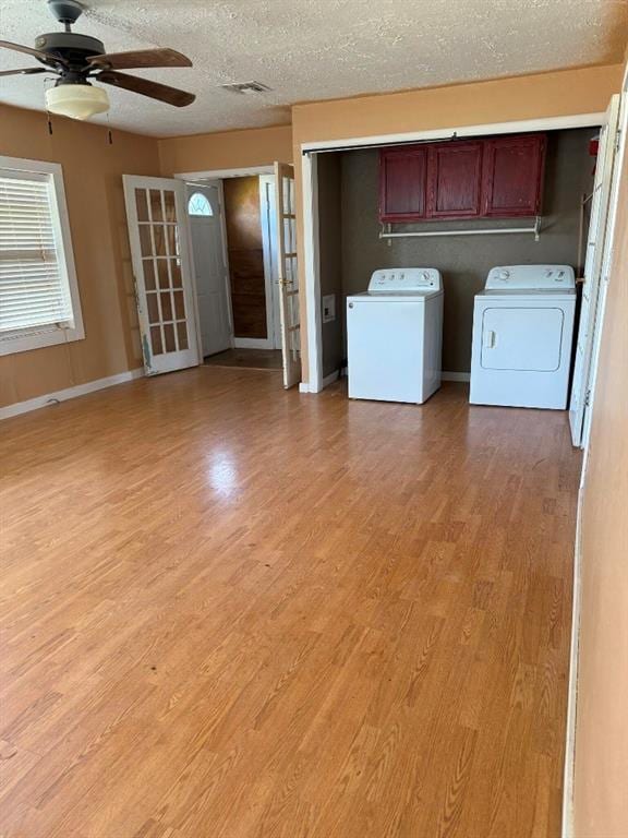 223 N Market St, Cordell, OK 73632 - washroom featuring cabinet space, separate washer and dryer, a ceiling fan, light wood-style flooring, and a textured ceiling