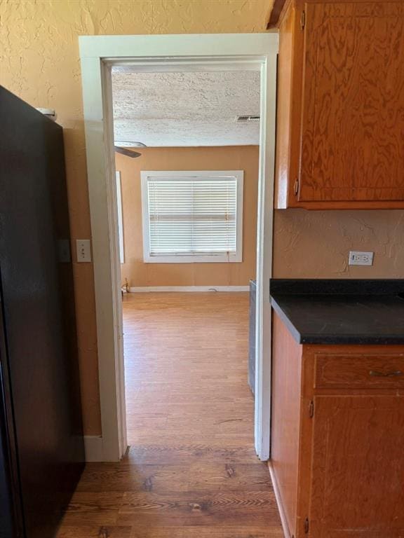 223 N Market St, Cordell, OK 73632 - hallway featuring wood finished floors, a textured wall, and a textured ceiling
