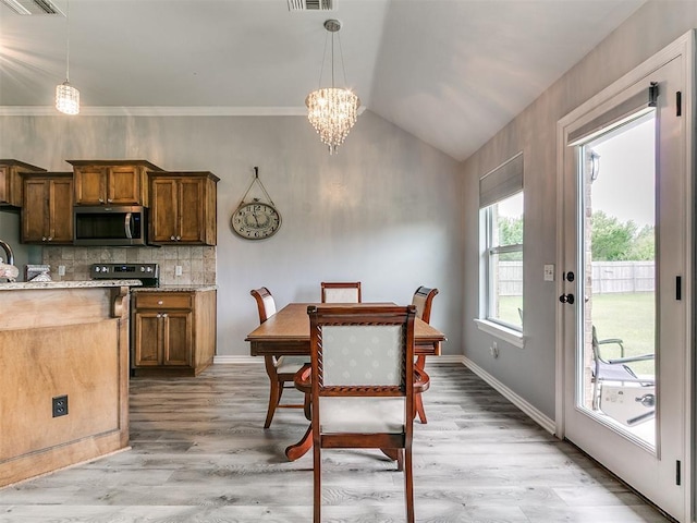 1401 Baycharter St, Norman, OK 73071 - dining space with a chandelier, light wood finished floors, and vaulted ceiling