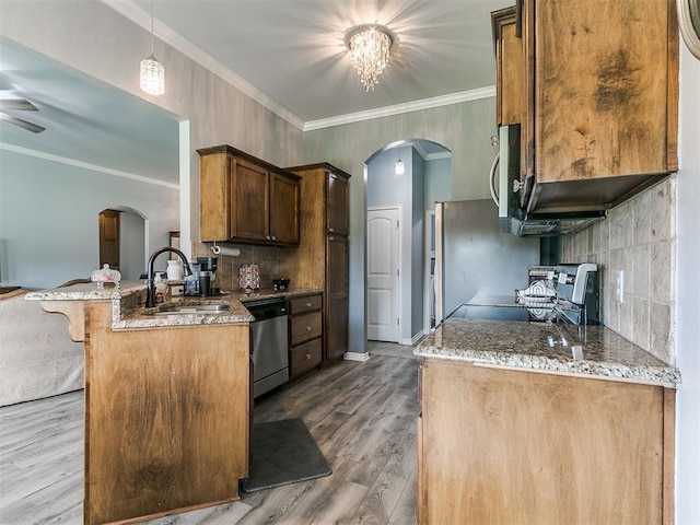 1401 Baycharter St, Norman, OK 73071 - kitchen featuring stainless steel appliances, arched walkways, a peninsula, wood finished floors, and ornamental molding