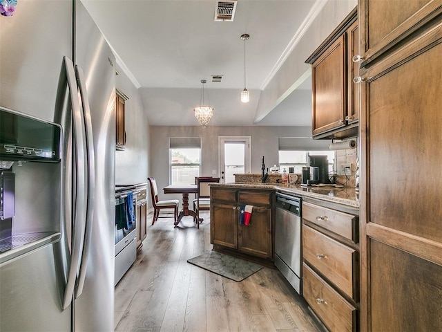1401 Baycharter St, Norman, OK 73071 - kitchen featuring appliances with stainless steel finishes, light wood finished floors, a peninsula, hanging light fixtures, and a chandelier