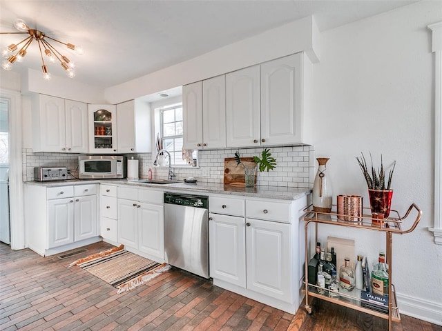 2647 NW 24th St, Oklahoma City, OK 73107 - kitchen featuring stainless steel dishwasher, tasteful backsplash, white cabinets, glass insert cabinets, and light stone counters