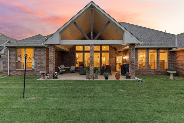 19804 Dalemead Way, Edmond, OK 73012 - back of house at dusk with a patio area, a yard, and brick siding