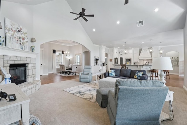 19804 Dalemead Way, Edmond, OK 73012 - living area with high vaulted ceiling, arched walkways, a ceiling fan, a fireplace, and a chandelier