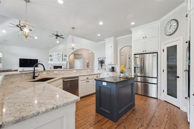 19804 Dalemead Way, Edmond, OK 73012 - kitchen featuring appliances with stainless steel finishes, ceiling fan, arched walkways, a kitchen island, and white cabinetry