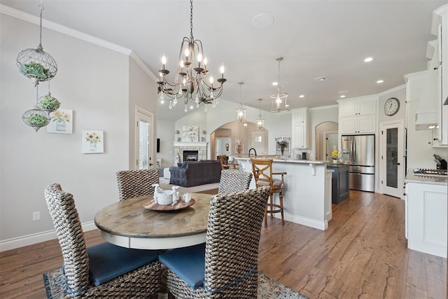 19804 Dalemead Way, Edmond, OK 73012 - dining area featuring recessed lighting, dark wood-style floors, arched walkways, crown molding, and a chandelier