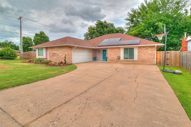 100 Three Oaks Dr, Midwest City, OK 73130 - ranch-style home with brick siding, a garage, concrete driveway, solar panels, and a shingled roof