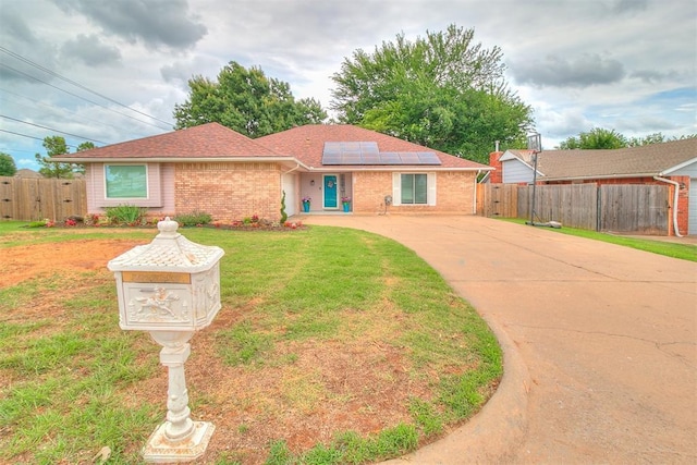 100 Three Oaks Dr, Midwest City, OK 73130 - ranch-style home with concrete driveway, brick siding, solar panels, and roof with shingles